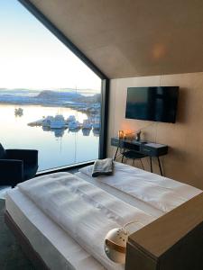 BøRingstad Resort的一张大床,位于带大窗户的房间里