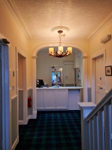 邓韦根Atholl House Skye的一个带厨房和吊灯的走廊