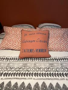 科隆别索尼约Studio Cosy tt confort proche aéroport的一张带枕头的床,上面有标志