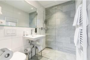 阿罗萨Hotel Alpensonne - Panoramazimmer & Restaurant的白色的浴室设有水槽和淋浴。