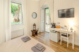 罗马GARDEN HOUSE - Luxury Guest House - Only Self Check in的白色的客房设有书桌和墙上的电视。