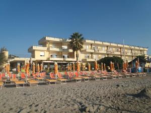 阿尔本加索尔酒店的一个带椅子和遮阳伞的海滩和一家酒店