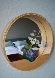 博帕德RHEIN-SUITES BOPPARD的卧室里带鲜花的圆木镜子