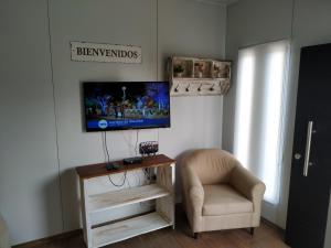 特立尼达岛Casita de Piedra 4的客厅配有椅子和墙上的电视