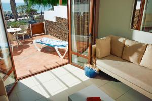 普拉亚布兰卡Grupotel Flamingo Beach的带沙发的客厅和天井。