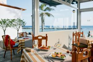 普拉亚布兰卡Grupotel Flamingo Beach的餐厅设有一张带食物的桌子,享有海景