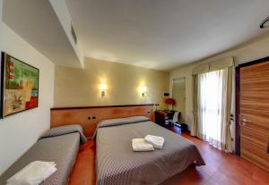 圣焦万尼泰亚蒂诺贝德商务酒店的一间卧室配有两张带毛巾的床
