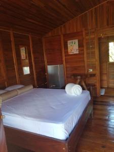 El AchioteCabañas Los Laguitos Rio Celeste的木制客房内的一间卧室,配有一张床
