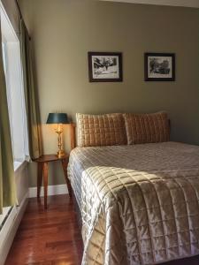 DownievilleCarriage House Inn的一间卧室配有一张床和一张带台灯的桌子