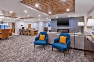 匹兹堡Staybridge Suites Pittsburgh Airport, an IHG Hotel的一间配有沙发、椅子和电视的等候室