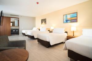 波哥大Hotel Habitel Select的酒店客房设有四张床和一张桌子。