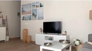 瓦伦西亚Apartamento equipado playa Valencia OnesDeMar的一间客厅,在白色的橱柜上配有电视