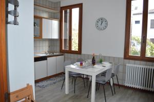 马格拉Noemi Venice Home的厨房配有桌椅和墙上的时钟