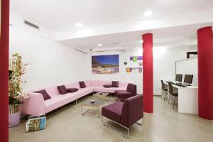 巴塞罗那生活梦想酒店的客厅配有粉红色的沙发和桌子