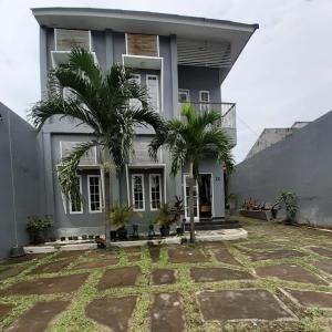 日惹Rumah Baraka的两棵棕榈树在房子前面
