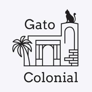 圣多明各Hostel Gato Colonial的一座建筑屋顶上的猫和棕榈树的图像
