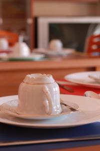 佩斯卡拉阿尔特亚酒店的桌上的盘子上一杯白咖啡