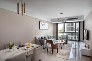无锡无锡馨乐庭新发公寓酒店的用餐室以及带桌椅的起居室。