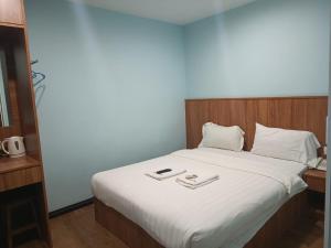 维多利亚AMBASSADOR LABUAN VIEW HOTEL的一张带白色床单的床和两张托盘