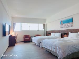 台东行云会馆的酒店客房设有两张床和电视。