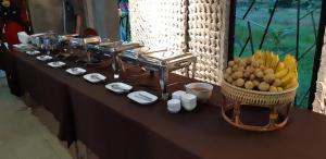 洛坤府拉蒂纳公寓酒店的一张桌子,上面放着一大堆食物和一篮水果