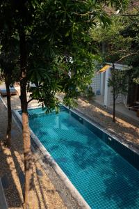 琅勃拉邦乐森精品酒店的树木繁茂的庭院中的一个游泳池