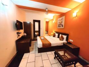 新德里Hotel Unistar的一间酒店客房,配有一张床和一台电视