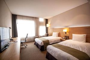 光州光州假日酒店的酒店客房设有两张床和一台平面电视。