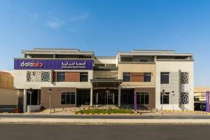 利雅德Dara Al Rayan的前面有紫色标志的建筑