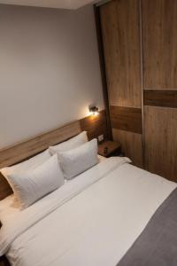 兹拉蒂博尔Per silvas apartman i spa的卧室配有一张带白色床单和枕头的大床。