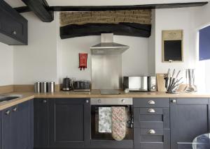 达宁顿堡Donington Cottage Apt 4的厨房配有灰色橱柜和炉灶烤箱