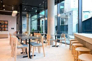 都柏林Staycity Aparthotels Dublin Mark Street的餐厅设有桌椅和窗户。