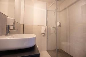 马萨纳Font Andorra Hostel的一间带水槽和玻璃淋浴的浴室