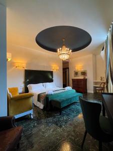 奥尔比亚Kemani Villa Sara Olbia的一间卧室配有一张大床和一个吊灯。