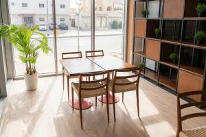 利雅德Dara Al Rayan的配有大窗户的客房内的桌椅