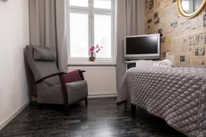 凯乌鲁IK Hotel & Camping的一间卧室配有一张床、一把椅子和电视