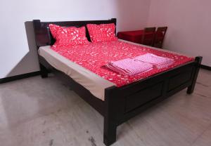 蓬蒂切里Villa Souhayl homestay的一张铺有红色床单和红色枕头的床