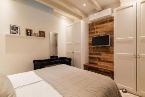 阿姆斯特丹Leidse Square 5 star Luxury Apartment的卧室配有1张床和1台砖墙电视