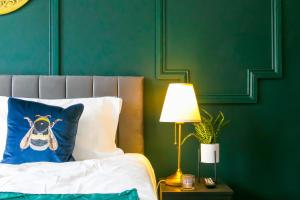 桑德兰The Mayfield Apartment Hotel的一张带蓝色枕头的床和一张桌子上的灯
