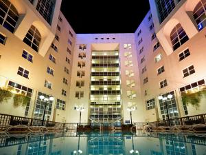 塞斯托-菲奥伦蒂诺诺富特佛罗伦萨诺德机场酒店的一座大型建筑,前面设有一个游泳池