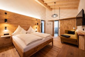 奥夫特尔施旺Die Zwei Sonnen Chalets的一间带一张大床的卧室,位于带木墙的房间