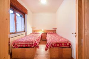 菲耶梅堡La pratolina piano terra的红色毯子的客房内的两张床