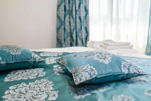 MăcinVILA SILFAR的一张带蓝色和白色枕头的床