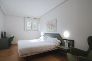 伊伦乌尔达尼比亚酒店的白色卧室配有床和沙发