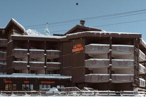 葱仁谷Le Val Thorens, a Beaumier hotel的雪中带白色阳台的建筑