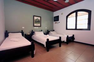 乌巴图巴Giprita Wellness Hotel Ubatuba的客房设有两张床和窗户。