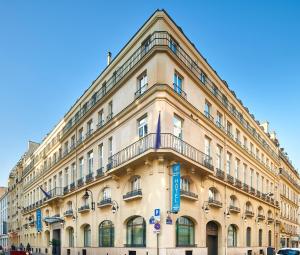 巴黎Hotel Vacances Bleues Provinces Opera的一座带蓝色标志的大型棕褐色建筑