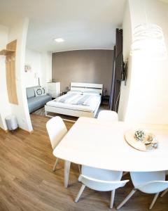 梅拉诺Flow Apartments Piave的配有一张床和一张桌子及椅子的房间