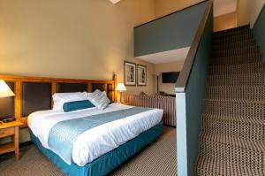 惠斯勒Blackcomb Lodge的一间酒店客房,设有一张床和一个楼梯