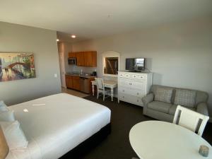 绍斯波特River Hotel of Southport的一间卧室配有一张床、一张沙发和一张桌子
